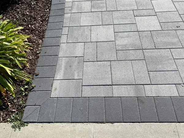 Gray paver walkway with a dark charcoal border